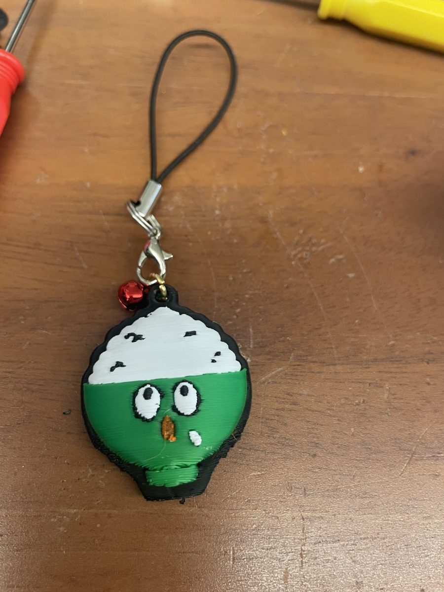 完成したごはん茶碗のキーホルダー。赤い鈴とストラップを付けて仕上げました